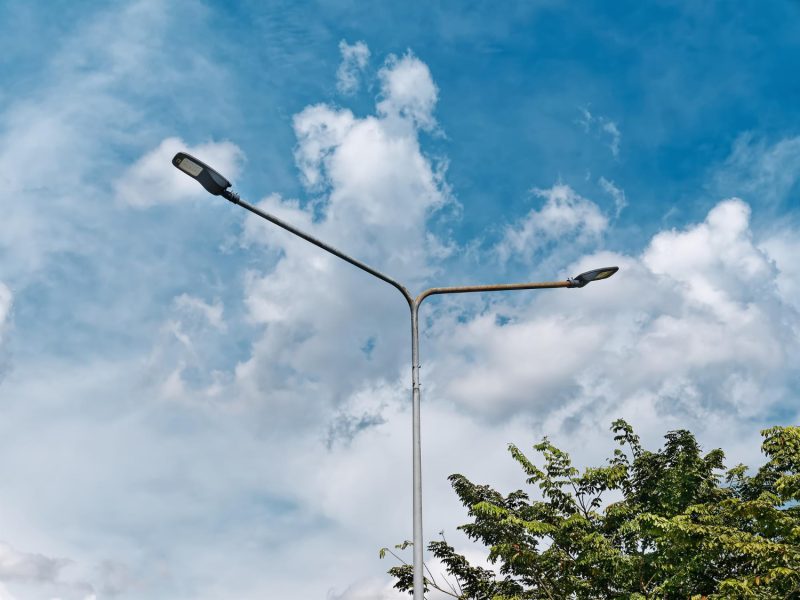 low-angle-view-street-lamps-post-against-blue-cloudy-sky