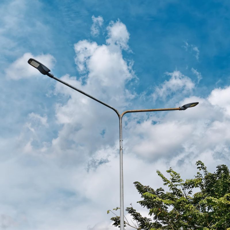 low-angle-view-street-lamps-post-against-blue-cloudy-sky